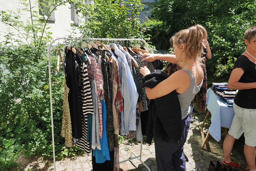 Frau sucht Kleider auf einem Flohmarkt